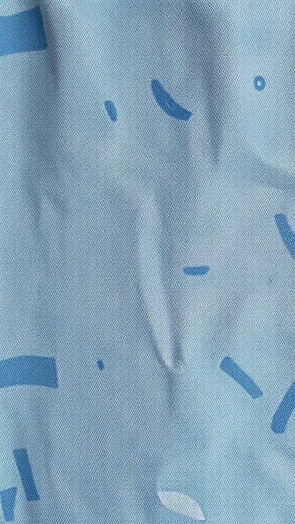 Close-up of distressed denim texture in soft blue tones with subtle patterns.
