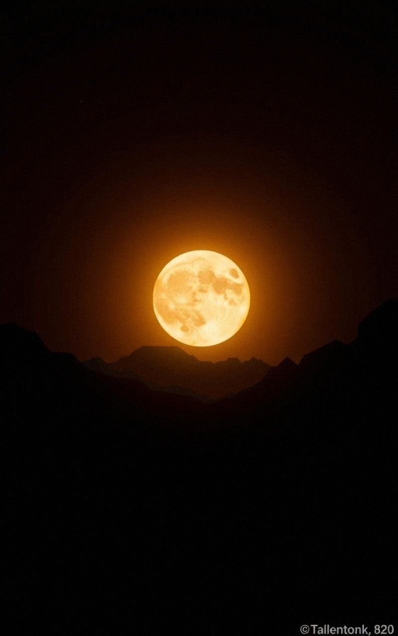 Golden Moonrise Behind Mountain Silhouettes