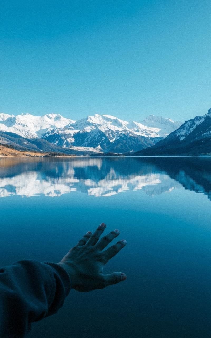 Crystal Clear Lake Reflecting Snowy Mountains