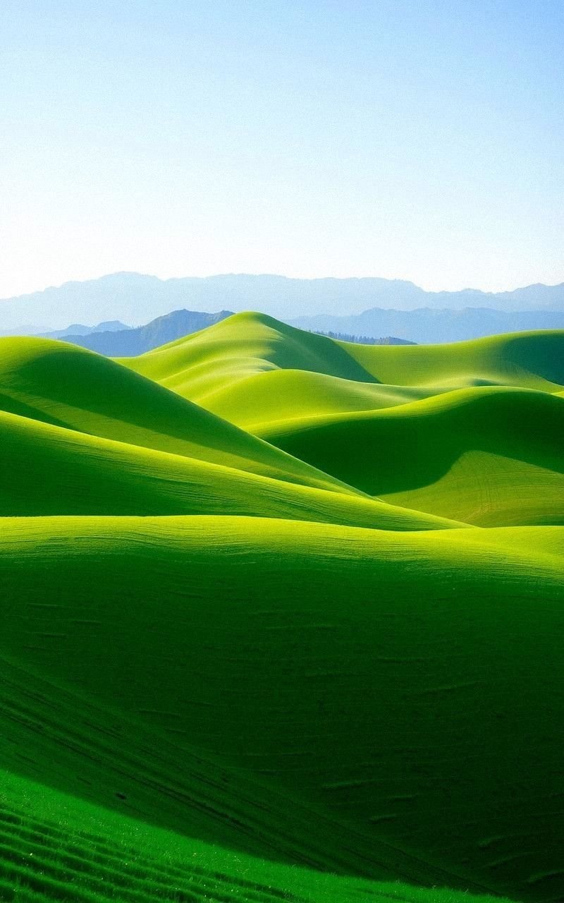 Lush Green Hills Rolling Toward Distant Peaks