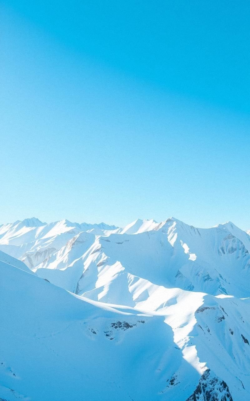 Snow-Capped Peaks Against Clear Blue Sky