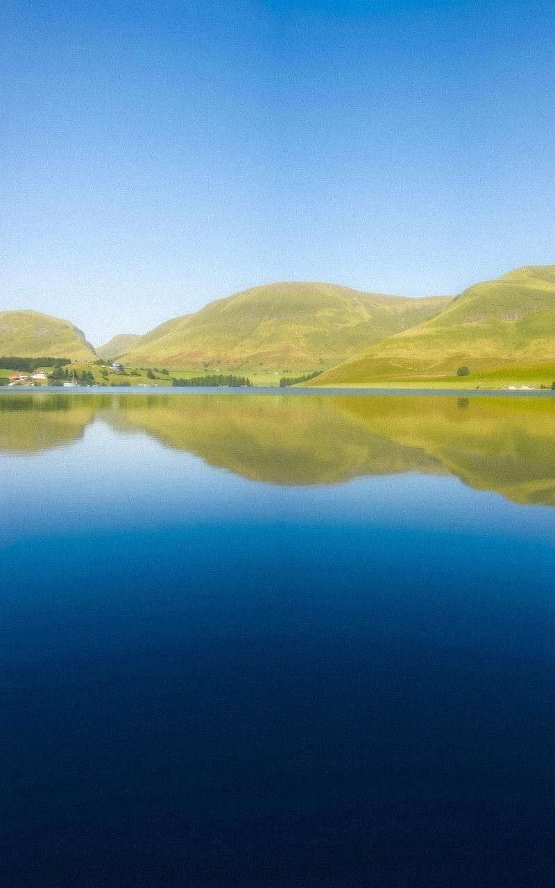 Deep Blue Lake Reflection with Rolling Hills